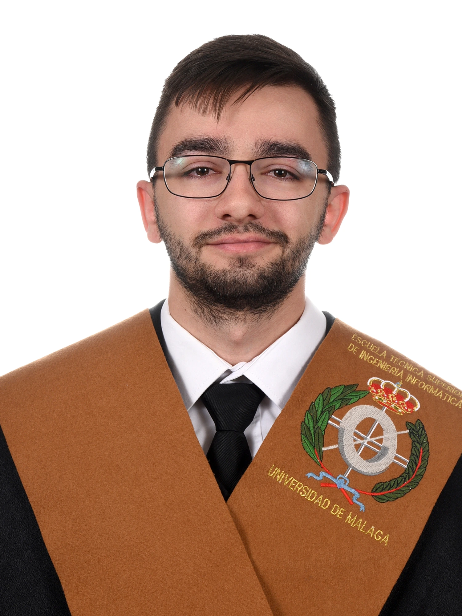 Antonio Bermúdez in his graduation attire, smiling and standing outdoors